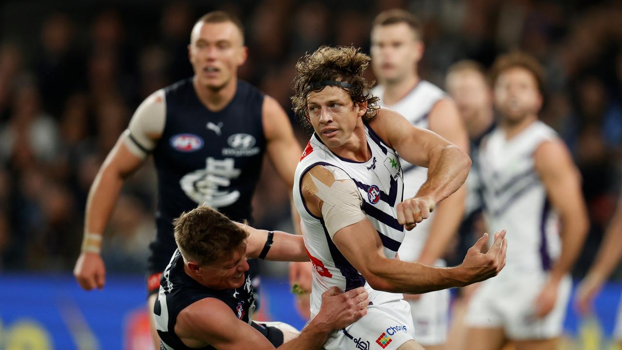 MELBOURNE, AUSTRALIA - JUNE 25: Nat Fyfe of the Dockers is tackled by Jack Newnes of the Blues during the 2022 AFL Round 15 match between the Carlton Blues and the Fremantle Dockers at Marvel Stadium on June 25, 2022 in Melbourne, Australia. (Photo by Michael Willson/AFL Photos via Getty Images)