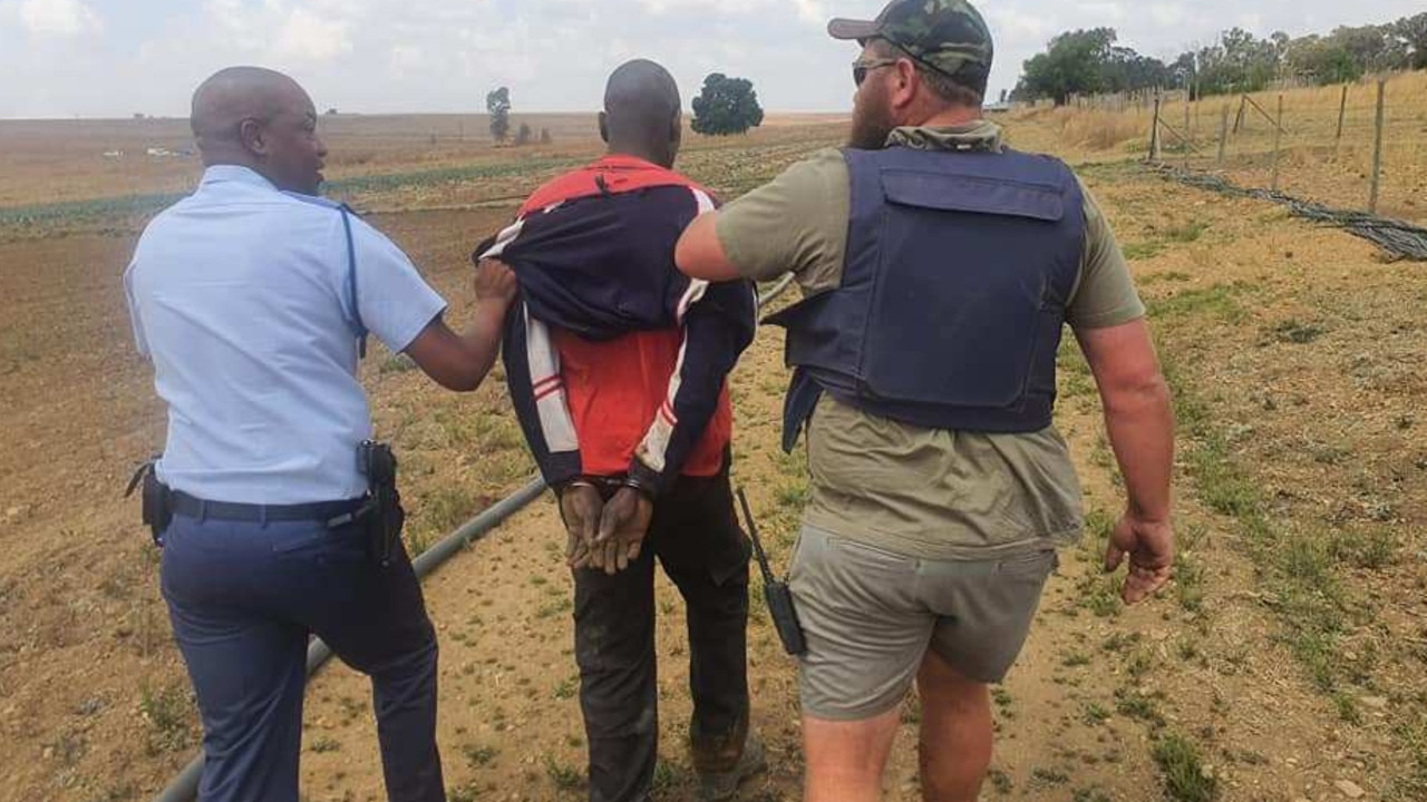 One of the suspects is led away by police. Picture: Jamie Pyatt