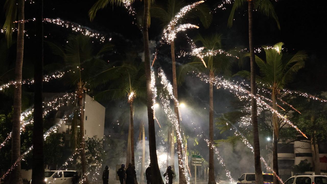 Fireworks explode during clashes with police in Le Port. (Photo by Richard BOUHET / AFP)