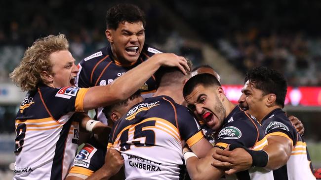 Thomas Banks is mobbed by his teammates after scoring a try.