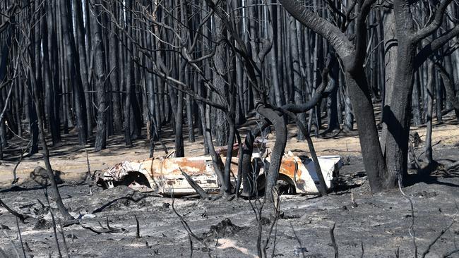 A burnt-out car in bushland burnt in the January 4 fires. Picture: AAP / David Mariuz