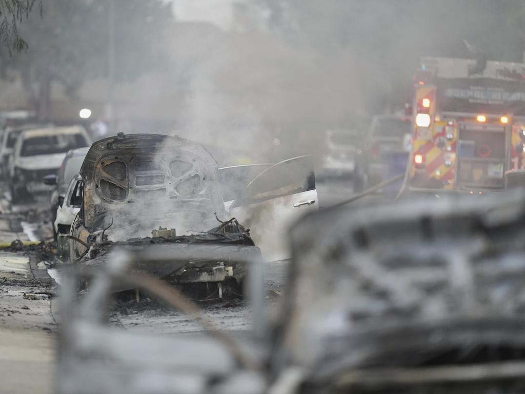 Vehicles are damaged as authorities work the scene where a small plane crashed into a San Diego neighbourhood. Picture: AP/Gregory Bul.