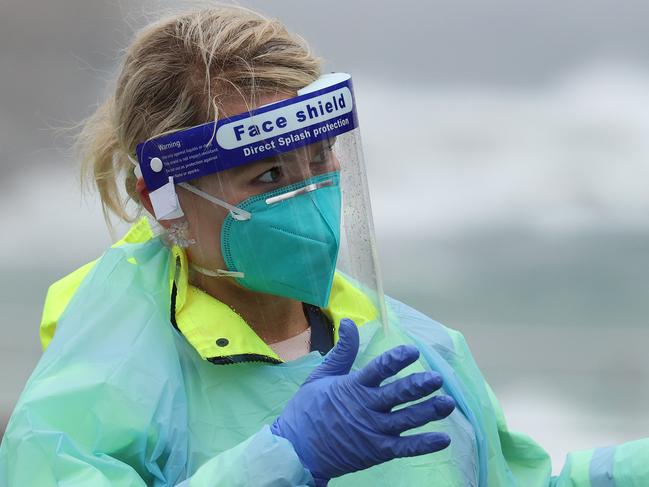 SYDNEY, AUSTRALIA - NewsWire Photos October 25, 2020: Pictured: Wearing rain gear is Registered Nurse Francee Drew speaking with other nurses while they wait for the next patient at St VincentÃs Hospital Bondi Beach Covid testing site in Sydney, NSW. Picture: NCA NewsWire / Dylan Coker