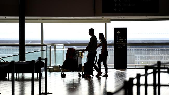 Travellers arrive to check in to one of only a handful of departing flights at the Brisbane international airport on Monday. Pictures: AAP