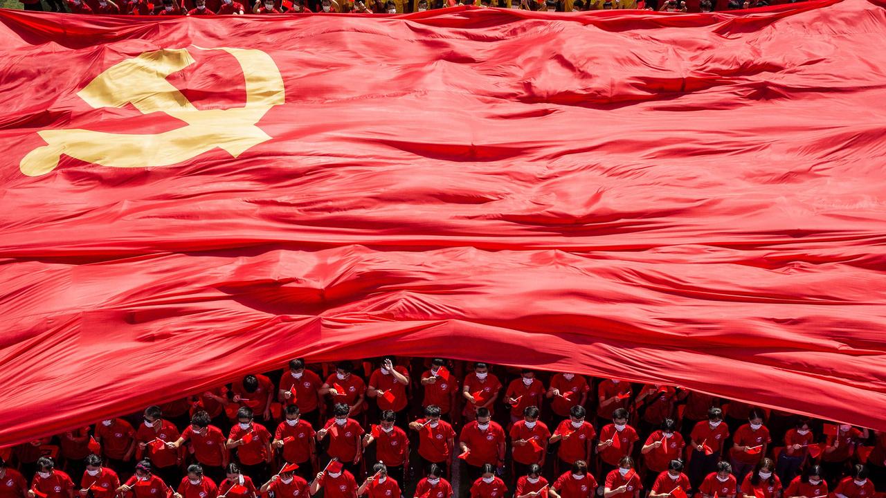 Uni students with the flag of the Communist Party of China to mark the party's 100th anniversary during an opening ceremony of the new semester in Wuhan. Picture: AFP/China OUT