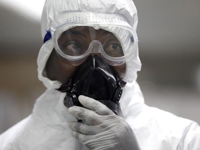 All precautions ... a Nigerian health official waiting to screen passengers for Ebola at the arrivals hall in Lagos, Nigeria. Picture: AP Photo/Sunday Alamba