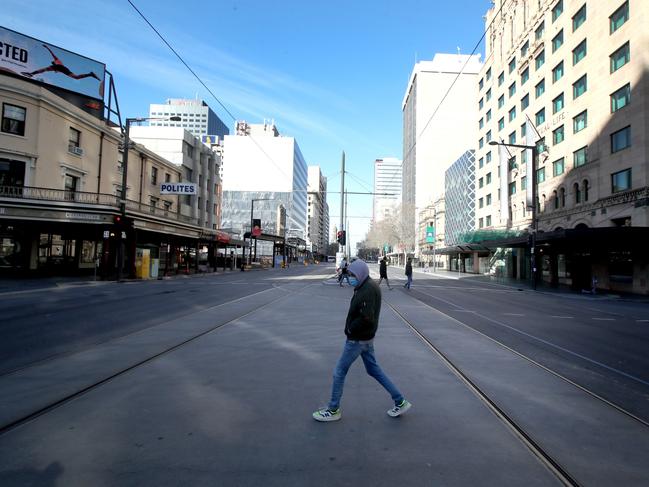 A man walks across an empty King William Street on Wednesday. Photo by Kelly Barnes/Getty Images.