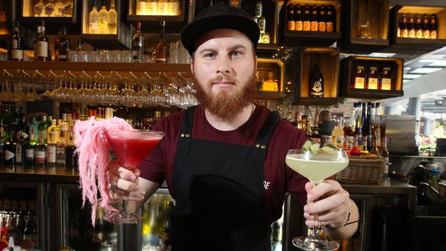 The Village bartender Luke Muller holds a fairy floss martini and a vera green cocktail.