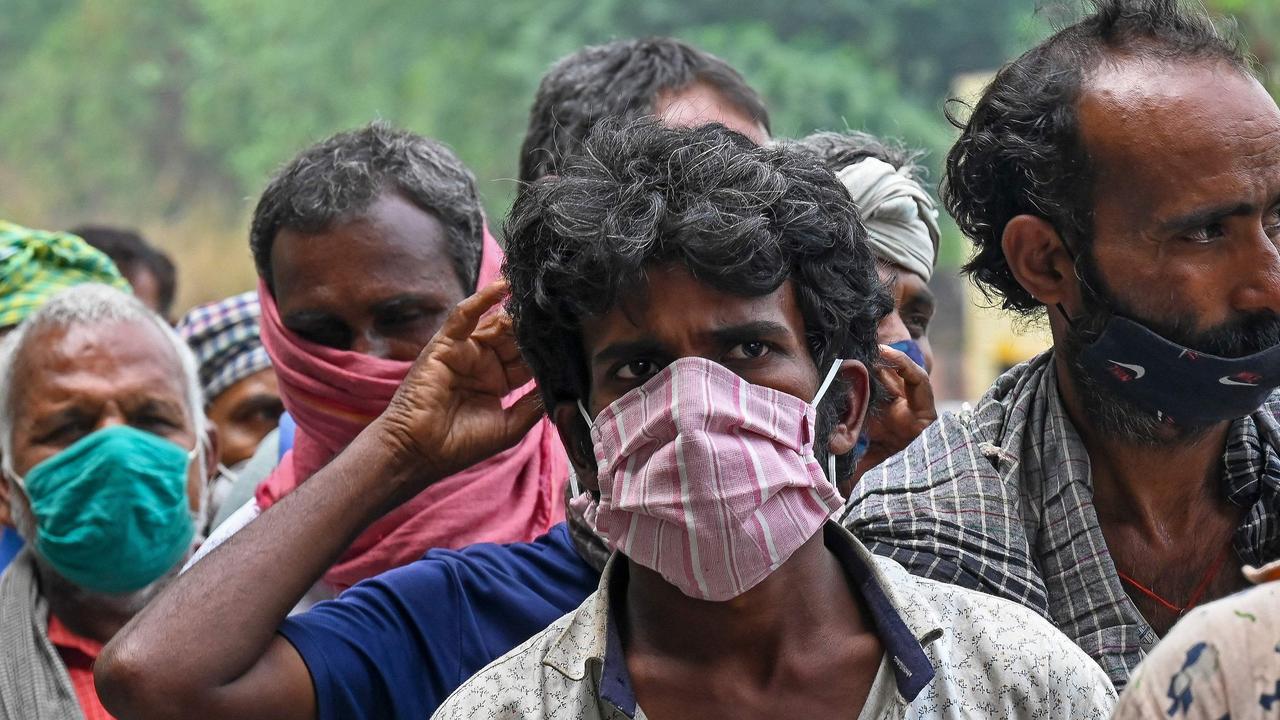 Homeless men and former labourers left out of work due to the lockdown queue as food volunteers in New Delhi. Picture: Prakash Singh/AFP