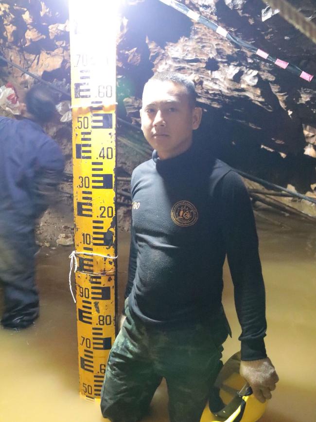 A Thai Navy diver beside a flood level indicator in Tham Long cave.