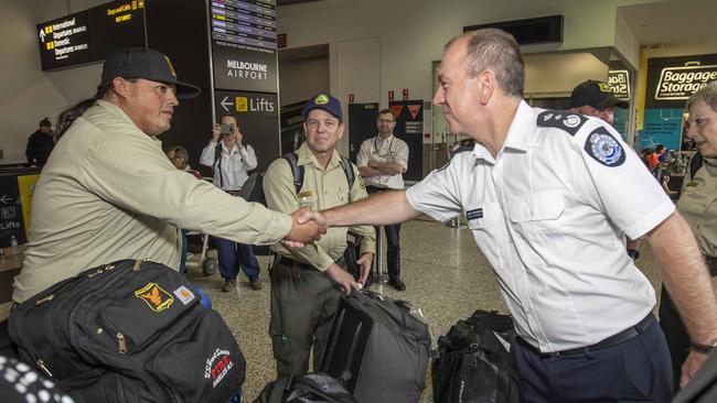 Deputy Emergency Management Commissioner, Chris Stephenson (right) shakes hands with a US firefighter. Picture: Tim Carrafa