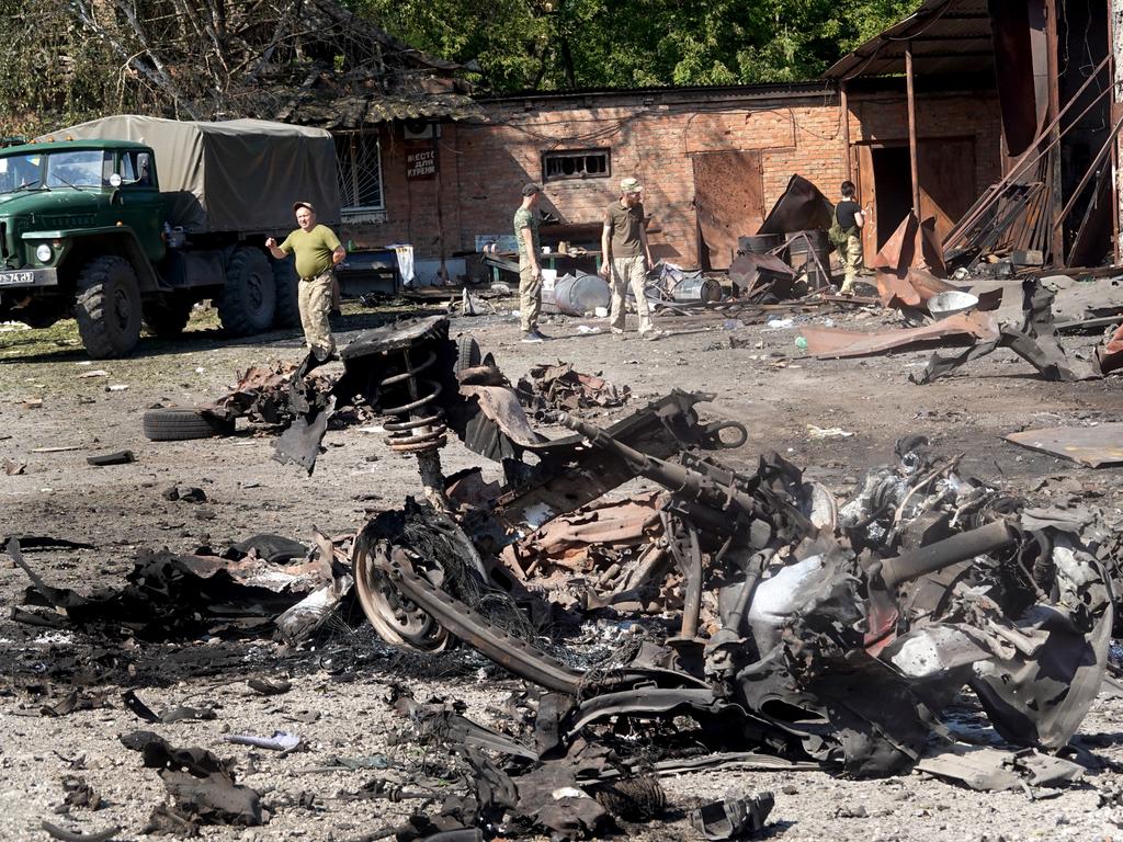 Soldiers survey damage and salvage items after a projectile hit Druzhkivka in easternUkraine. Picture: Getty Images