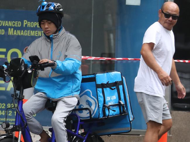 Food delivery cyclists on Sydney footpaths and using phones while riding. Photo: John Grainger