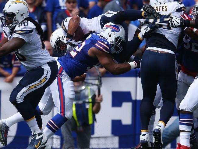 Donald Brown #34 of the San Diego Chargers is tackled by Preston Brown #52 of the Buffalo Bills.