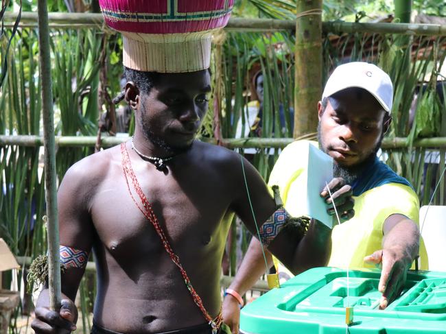 In this Nov. 29, 2019, photo, the Upe members vote at a men-only voting booth in the Bougainville referendum in Teau, Bougainville, Papua New Guinea. All across the Pacific region of Bougainville, people have been voting in a historic referendum to decide if they want to become the worldâ€™s newest nation by gaining independence from Papua New Guinea. (Jeremy Miller, Bougainville Referendum Commission via AP)