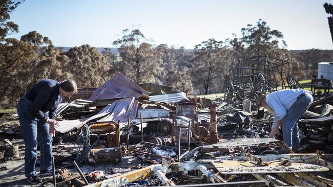 Brian and Elizabeth Blakeman inspect the bushfire damage to their property in Wairewa, Victoria, on Sunday. Picture: Getty Images