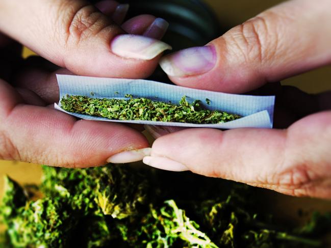 A marijuana joint being rolled by hand. Istock