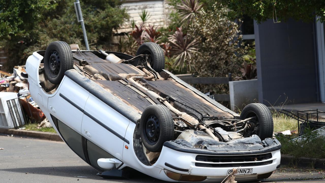 An overturned car in Dawson St, Lismore in the aftermath of the floods. Photo: Jason O'Brien