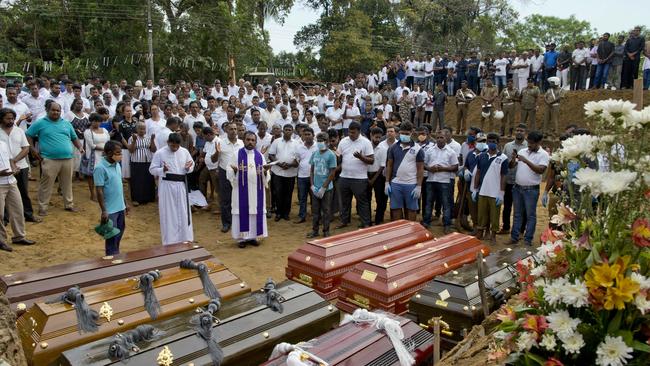 A priest conducts religious rituals during a mass burial for victims in Negombo. Picture: Gemunu Amarasinghe/AP