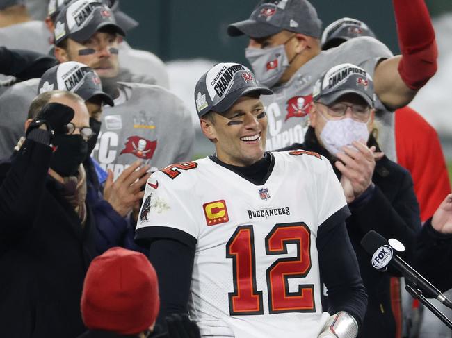 GREEN BAY, WISCONSIN - JANUARY 24: Tom Brady #12 of the Tampa Bay Buccaneers celebrates with teammates after their 31 to 26 win over the Green Bay Packers during the NFC Championship game at Lambeau Field on January 24, 2021 in Green Bay, Wisconsin.   Dylan Buell/Getty Images/AFP == FOR NEWSPAPERS, INTERNET, TELCOS & TELEVISION USE ONLY ==