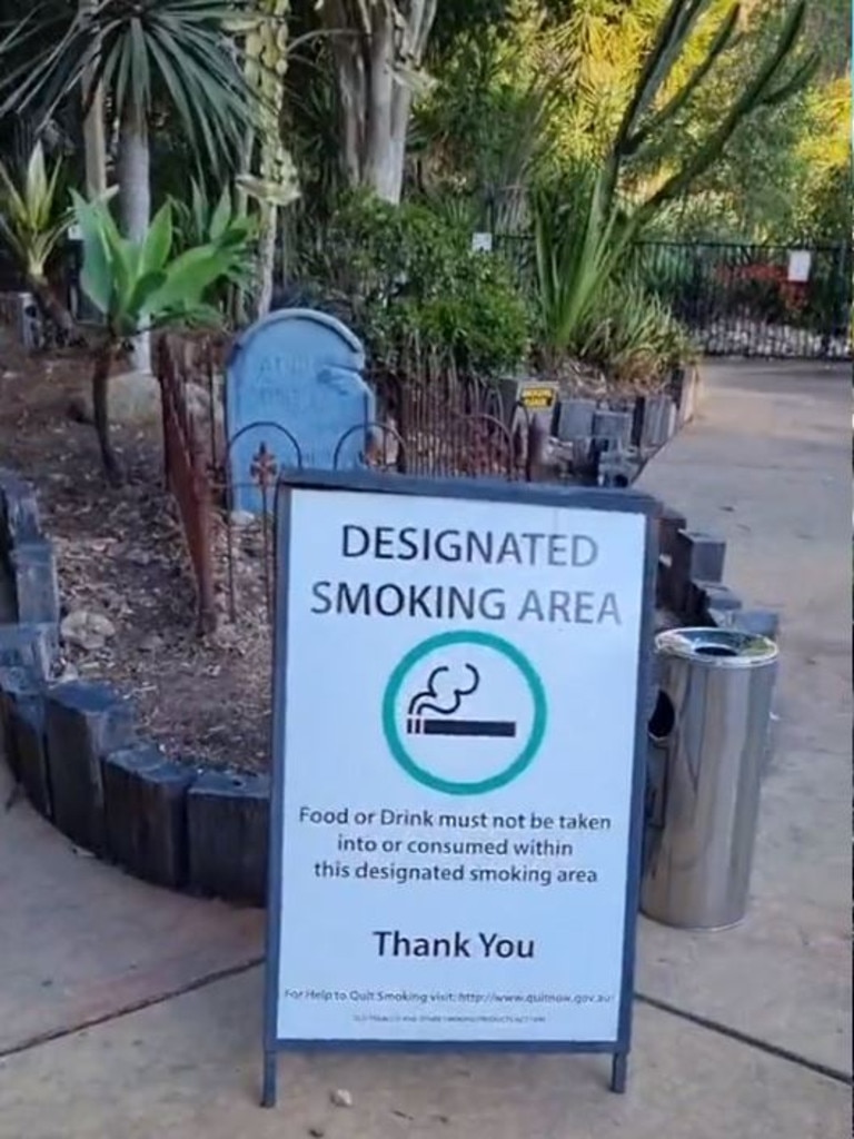 A gravestone can be seen behind the smoking area sign. Picture: Kate Barker/TikTok