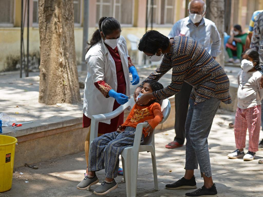 A medical worker takes a swab sample of a child for a test for COVID-19 in Hyderabad. Picture: Noah Seelam