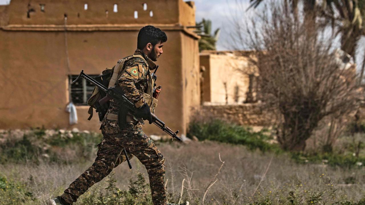 A Syrian Democratic Forces soldier runs for cover during shelling on the Islamic State group's last holdout of Baghouz in the eastern Deir Ezzor province in Syria. Picture: Delil Souleiman/AFP