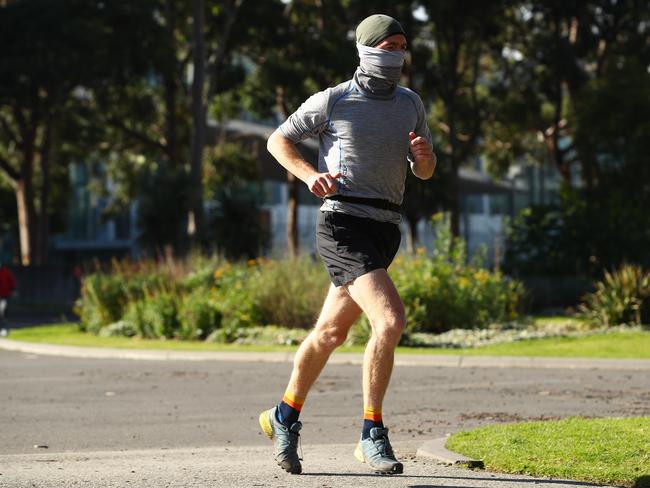 A masked man running through the Carlton Gardens. Picture: Robert Cianflone/Getty Images