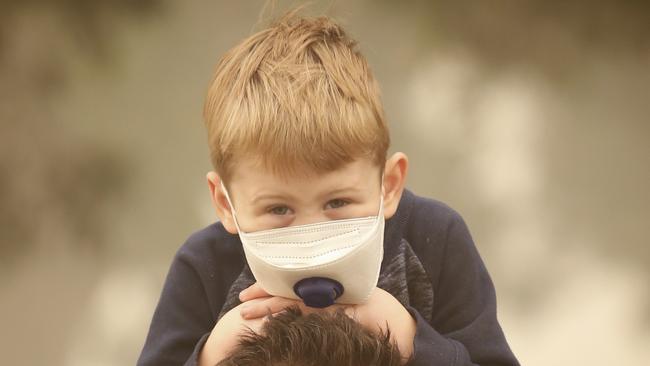 Four-year-old Cole wearing a mask in the heavy Mallacoota smoke. Picture: David Caird