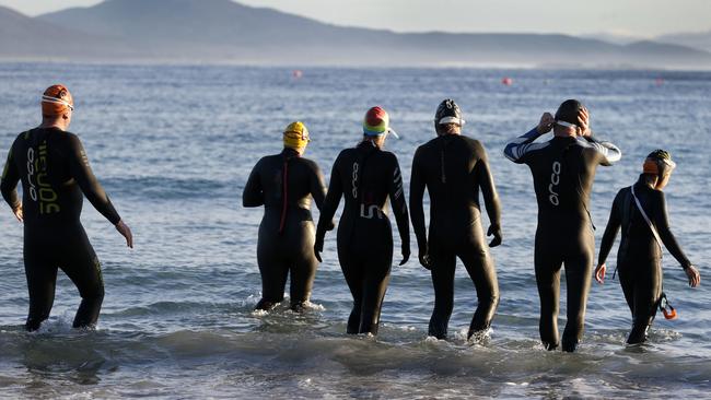 Coffee Club swimmers head off from Waub’s Bay for their daily swim. Picture: KIM EISZELE