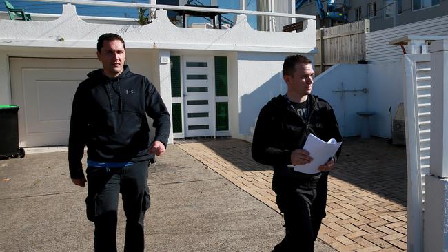 Detective Sergeant Marinello (right) and Senior Probationary Constable Cudmore door-knock a Curl Curl residence. Picture: Toby Zerna