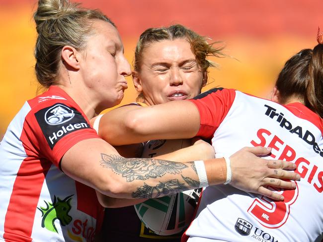 Julia Robinson (centre) of the Broncos is tackled by Holli Wheeler (left) and Jessica Sergis (right) in the NRL Women's Premiership match on Sunday.