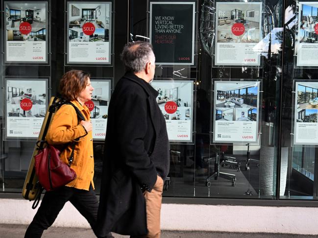 People pass a real estate agency in Melbourne on July 5, 2022, after Australia's Reserve Bank announcing a 0.5 percentage point increase in interest rates. Picture: William West