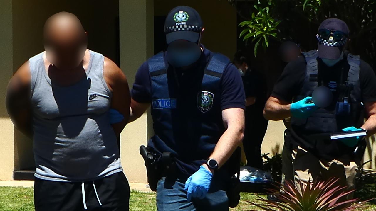 One of the six accused is led from the Northfield drug house by police. Picture: AFP