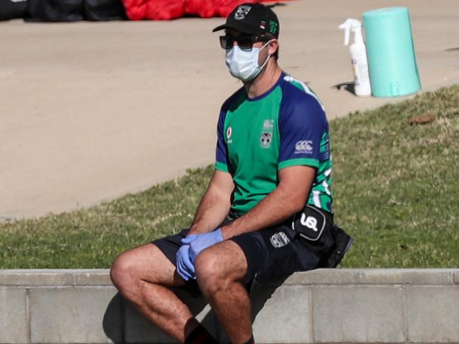 Players walk past a team official wearing a face mask during a New Zealand Warriors training session in Tamworth, NSW, Wednesday, May 5, 2020.   (AAP Image/David Gray) NO ARCHIVING