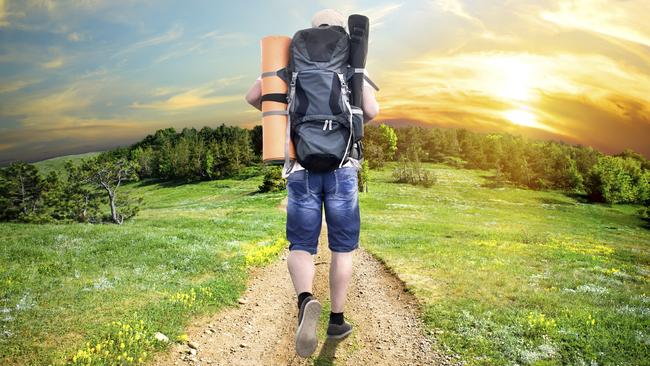 Man with a backpack walking on a country road