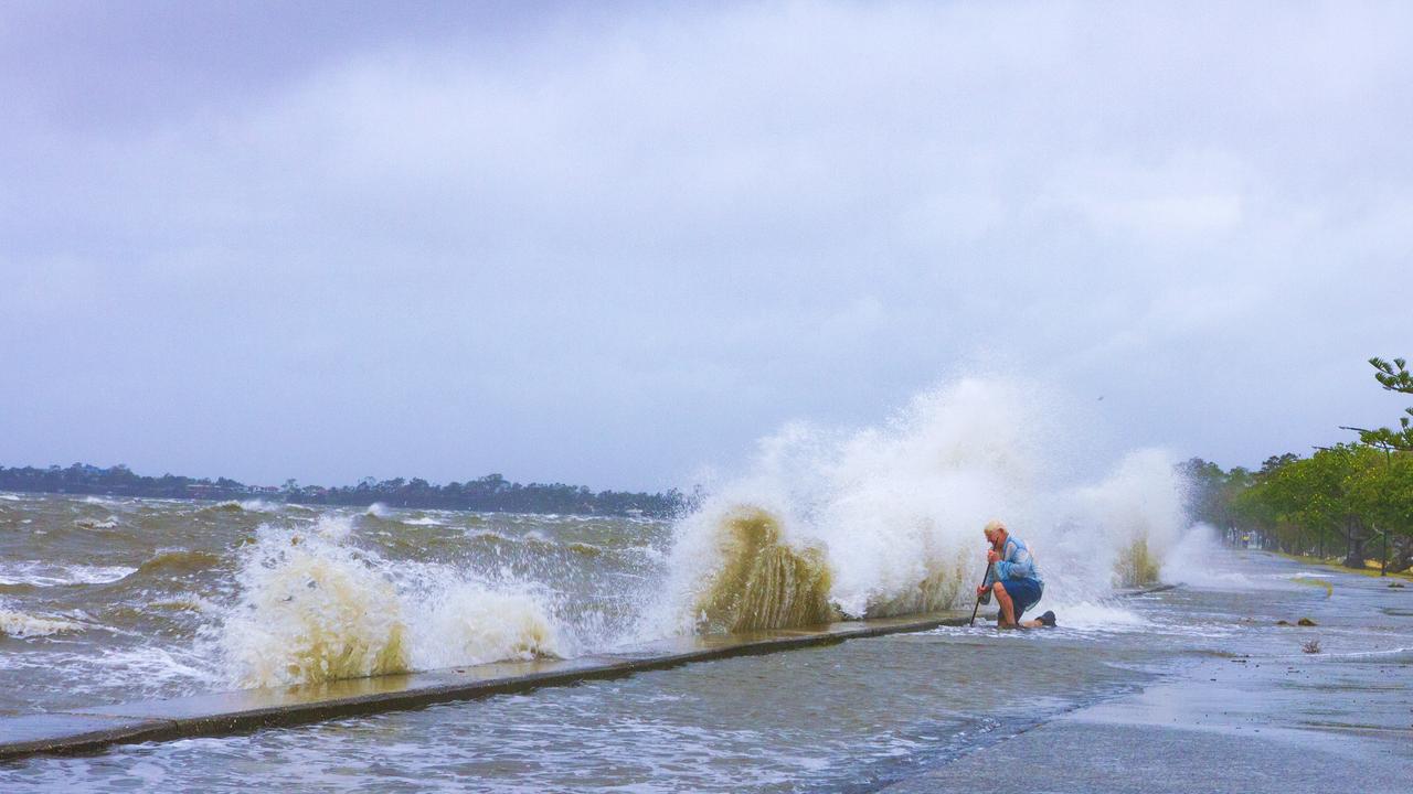 A Sandgate resident, concerned about flooding, pushes out into the floodwaters to unclog the drain pipes. PHOTO CREDIT: Dianna Jean Photography.