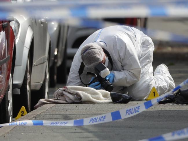 Forensic police examine and photograph clothing, shoes and a handbag at the scene after Jo Cox, 41, Labour MP for Batley and Spen, was shot and stabbed by an attacker. Picture: Getty.