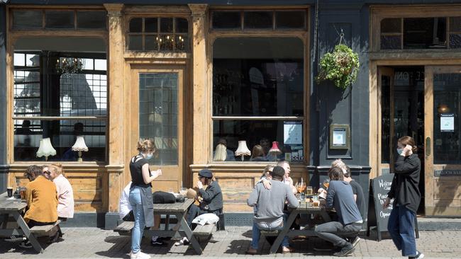 Customers drink outside the East Dulwich Tavern in London. Picture: Getty Images.