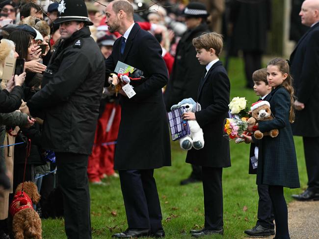 Prince William, Prince of Wales and his children Prince George of Wales (C), and Princess Charlotte of Wales and Prince Louis of Wales hold gifts they received. Picture: AFP