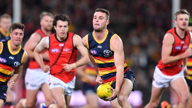 Brad Crouch handballs against Essendon. Picture: AAP Image/David Mariuz