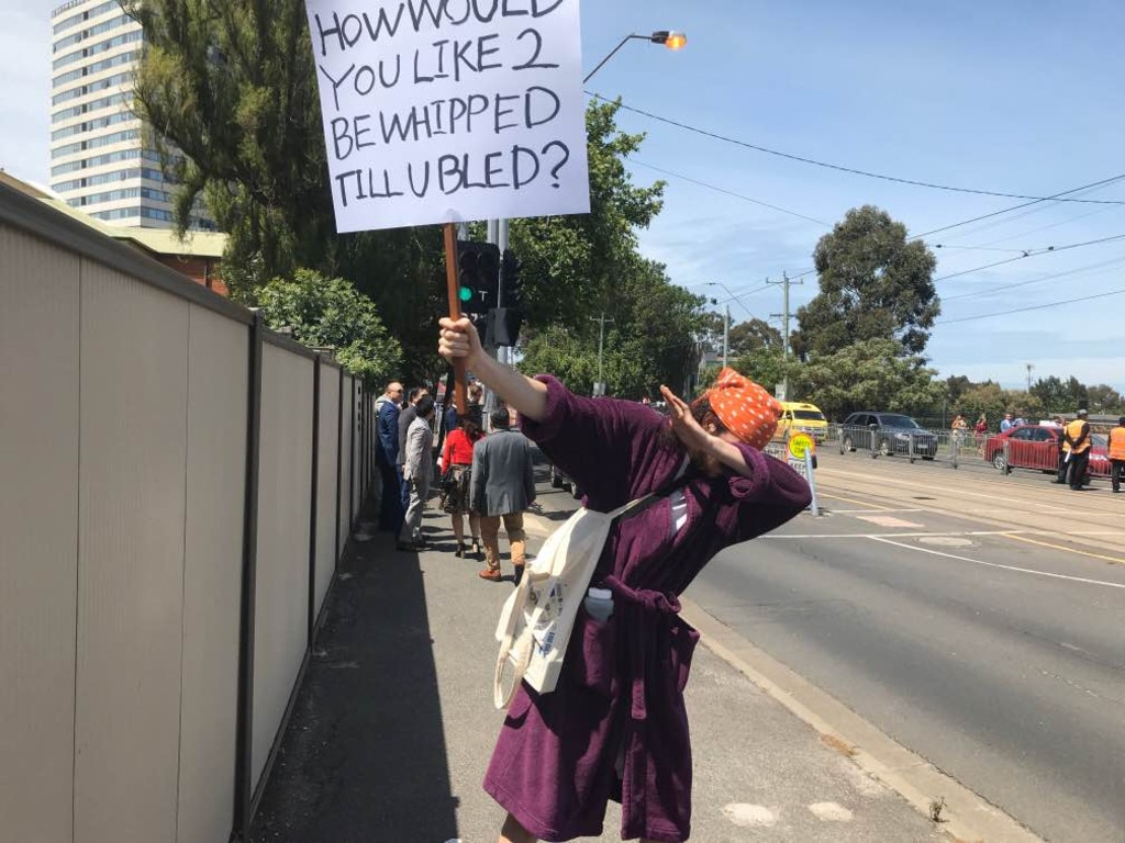 A protester outside the Melbourne Cup protests horse cruelty as well as littering.