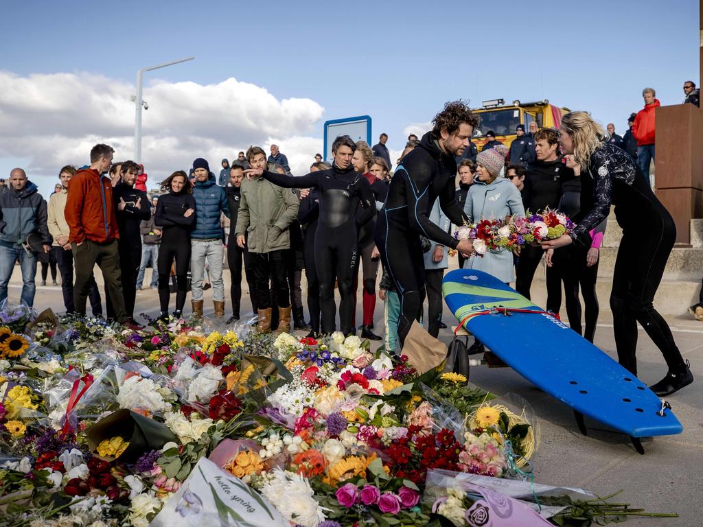 Mourners gather beside floral tributes during a commemoration at The Shore Surf Club at Scheveningen.