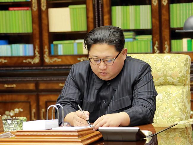 Kim Jong-un signs an order document of a test-fire of the intercontinental ballistic rocket Hwasong-15. Picture: KCNA/AFP