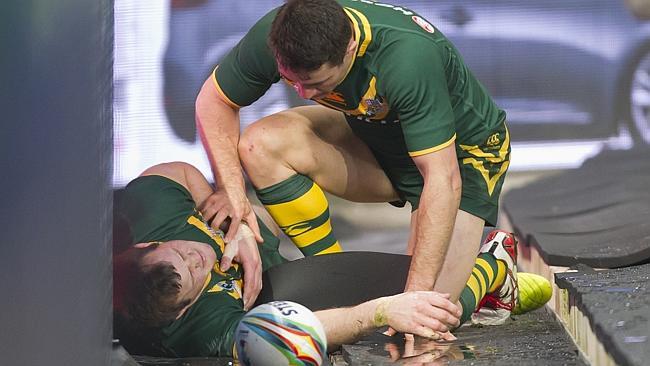 Australia's Brett Morris, left, is checked over by teammate Billy Slater after sliding into an advertising hoarding following his first try during the World Cup Final.