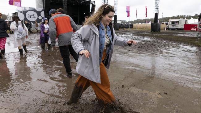 A woman wades through the flooded site of the Splendour in the Grass festival near Byron Bay. Picture: Getty Images