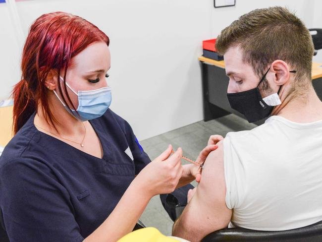 ADELAIDE, AUSTRALIA - NewsWire Photos NOVEMBER 4, 2021: SA Health vaccinator Tayla gives MSS Medical hotel security team leader Aiden Wilson a Covid booster vaccine at Wayville Vaccination Clinic. Picture: NCA NewsWire/Brenton Edwards