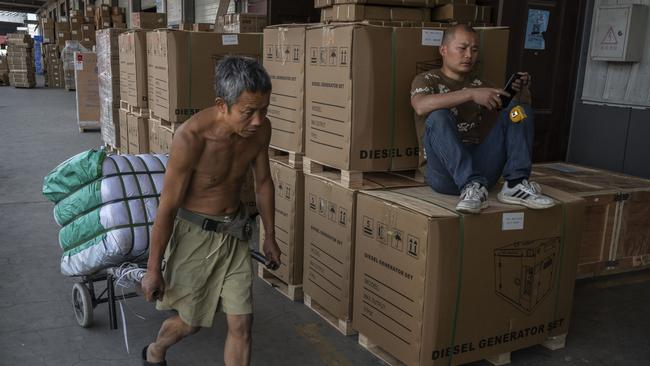 A worker pulls a cart with goods for export in Yiwu, Zhejiang Province, China. Picture: Kevin Frayer/Getty Images