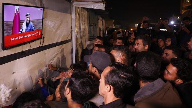 People in the Gaza Strip watch a press conference, held by Qatar PM Sheik Mohammed bin Abdulrahman bin Jassim Al-Thani, about a ceasefire. Picture: AFP