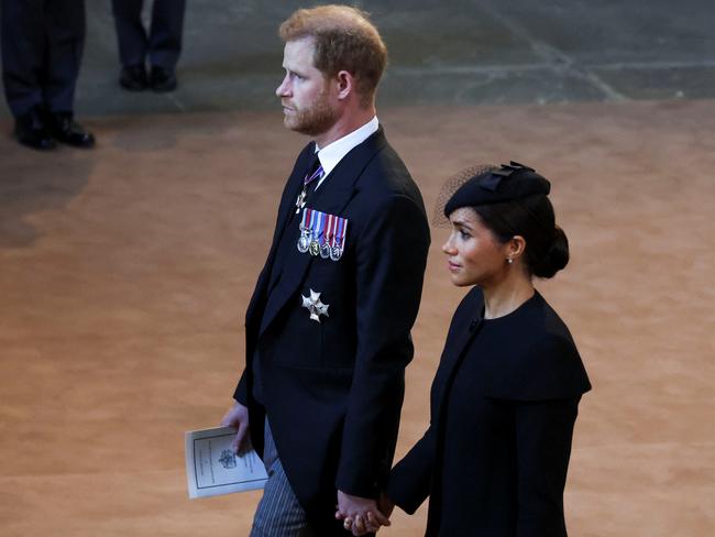 Harry and Meghan walk hand-in-hand behind the Queen’s coffin as it arrives at Westminster Hall from Buckingham Palace for her lying in state. Picture: AFP.